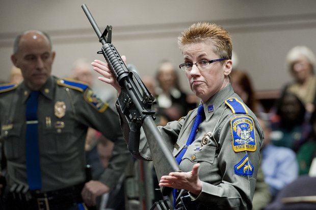 Detective Barbara J. Mattson, of the Connecticut State Police, holds up a Bushmaster AR-15 rifle, the same make and model of gun used by Adam Lanza in the Sandy Hook School shooting, Jan. 28, 2013. (AP/Jessica Hill)