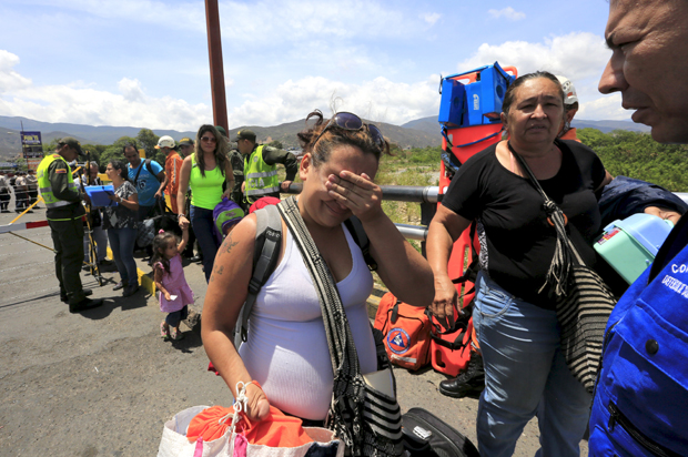 A Colombian woman cries after being deported from Venezuela, as she arrives with her family at the Simon Bolivar bridge border, near Villa del Rosario village, Colombia, August 25, 2015. (Reuters/Jose Miguel Gomez)