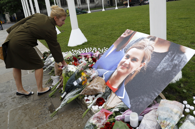 A woman leaves flowers at a memorial to Jo Cox in London, June 17, 2016. (Reuters/Stefan Wermuth)