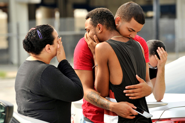 Friends and family members embrace outside the Orlando Police Headquarters during the investigation of a shooting at the Pulse night club, Orlando, Florida, June 12, 2016. (Reuters/Steve Nesius)