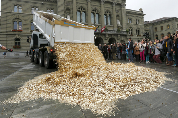A truck dumps coins onto Federal Square in Bern, Switzerland, during a an event organized by the Committee for the initiative "CHF 2,500 monthly for everyone," October 4, 2013. (Reuters/Denis Balibouse)