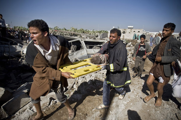 Yemenis carry the body of a child they uncovered from under the rubble of houses destroyed by Saudi airstrikes near Sana'a Airport, Yemen on March 26, 2015 (AP/Hani Mohammed)