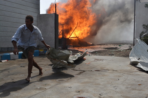 A Yemeni man flees a gas station after it was hit by a Saudi-led coalition airstrike in Houdieda, Yemen on February 5, 2016 (Reuters/Abduljabbar Zeyad)