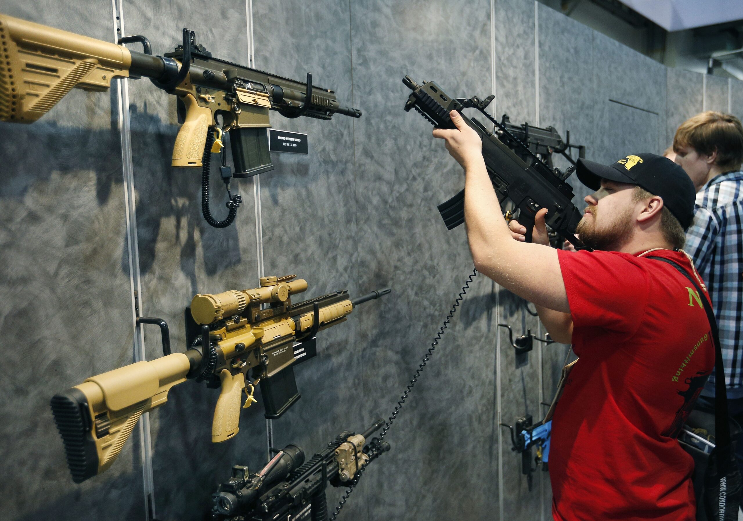 FILE - In this Jan. 19, 2016 file photo, Nolan Hammer looks at a gun at the Heckler & Koch booth at the Shooting, Hunting and Outdoor Trade Show in Las Vegas. Nearly two-thirds of Americans expressed support for stricter gun laws, according to an Associated Press-GfK poll released Saturday, July 23, 2016. (AP Photo/John Locher, File)