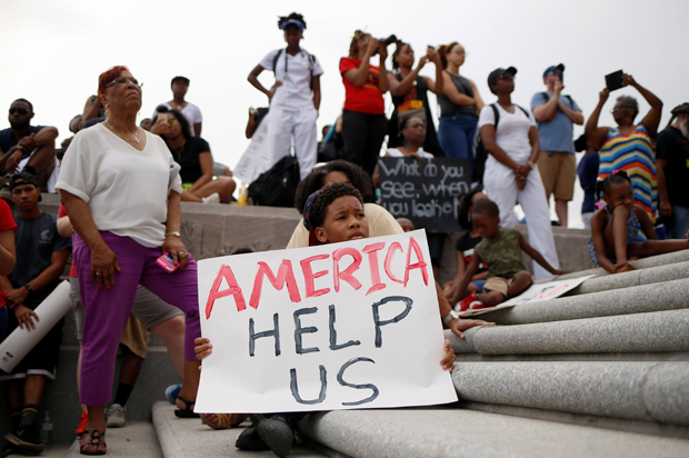 Kerron Stewart, 10, sits with demonstrators on the steps of the Louisiana State Capitol building in Baton Rouge, Louisiana, July 10, 2016. (Reuters/Shannon Stapleton)