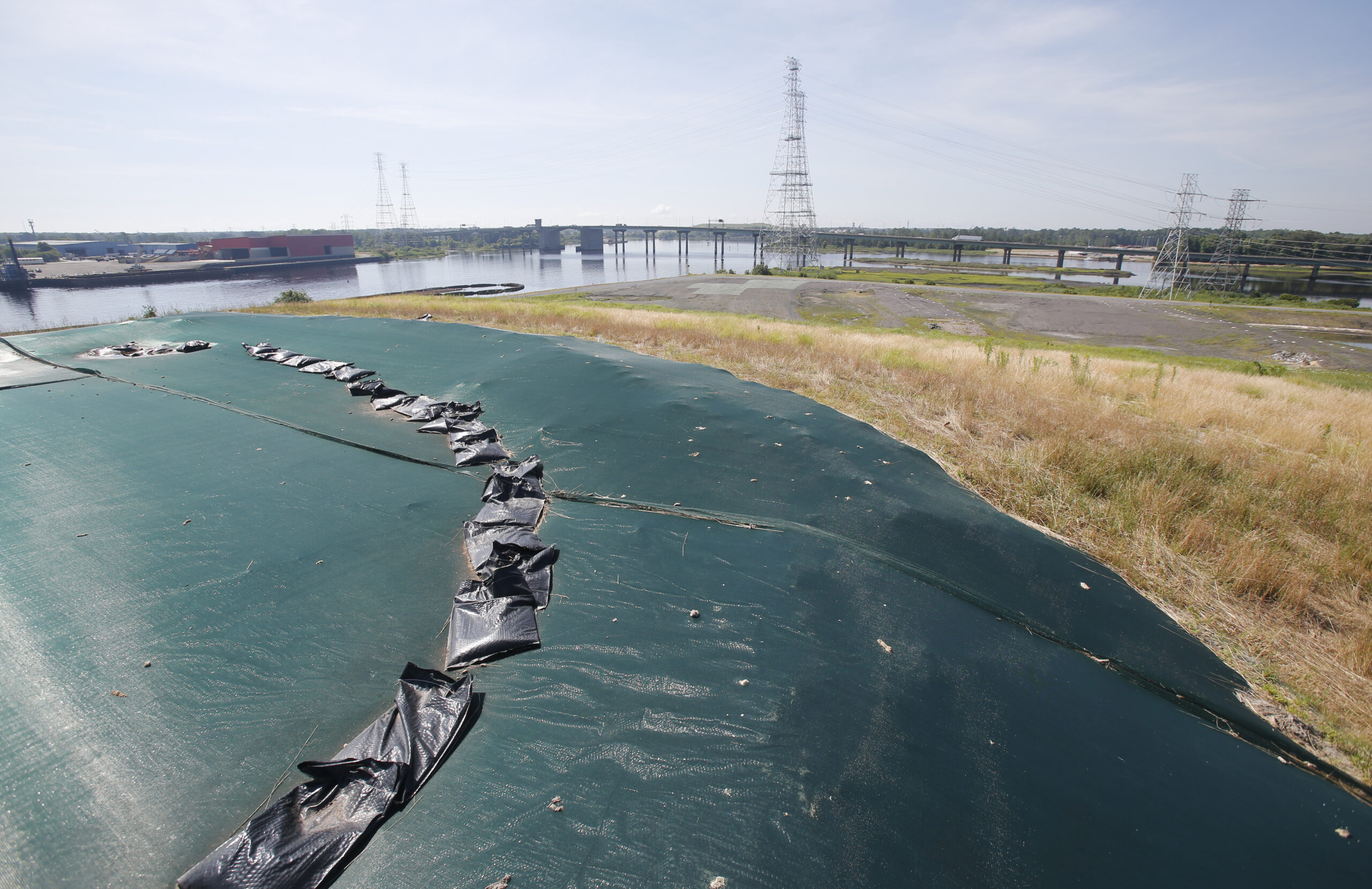 A non-permeable cover tops Coal Ash Basin B along the banks of the Elizabeth River in Chesapeake, Va., Monday, June 27, 2016. A lawsuit has gone to a judge over environmentalists claim that there are leaks of arsenic and other heavy metals into a river near Dominion�s abandoned Chesapeake power plant from the coal Ash pits in violation of the Clean Water Act. (AP Photo/Steve Helber) (AP)