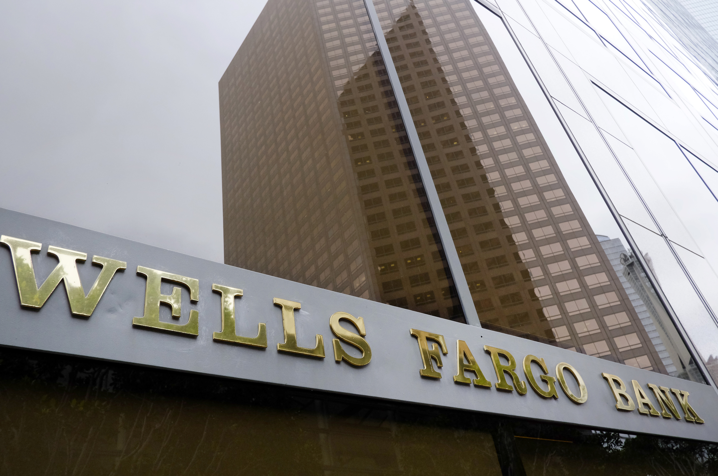 FILE - In this May 5, 2015, file photo, a downtown building is reflected in the windows of a Wells Fargo Bank in Los Angeles. Wells Fargo reports financial results on Friday, July 15, 2016. (AP Photo/Richard Vogel, File) (AP)
