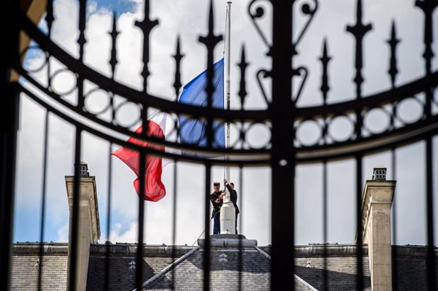A Republican Guard lowers the French national flag to half-mast at the Elysee Palace in Paris, France, July 15, 2016. (Reuters/Christophe Petit Tesson)