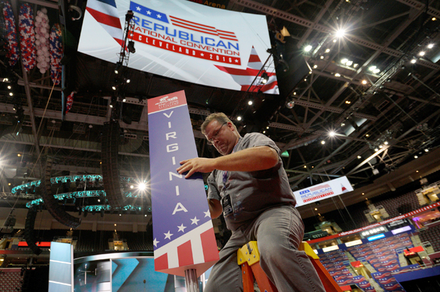 A worker installs the sign for the Virginia delegation on the floor of the Republican National Convention in Cleveland, July 15, 2016. (Reuters/Rick Wilking)