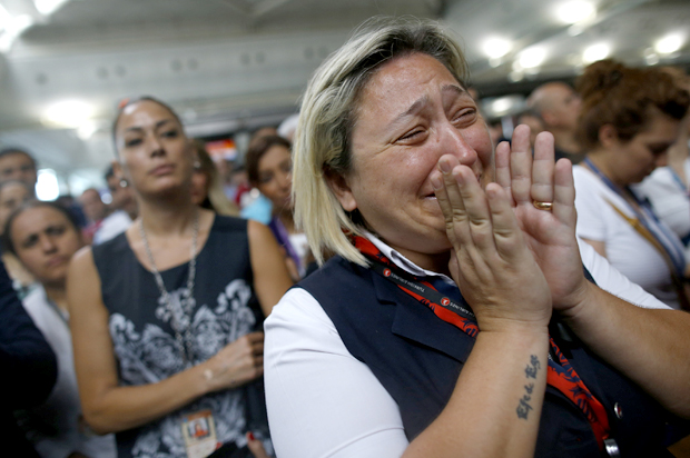 A woman reacts as Family members, colleagues and friends of the victims of Tuesday blasts gather for a memorial ceremony at the Ataturk Airport in Istanbul, Thursday, June 30, 2016. (AP/Emrah Gurel)