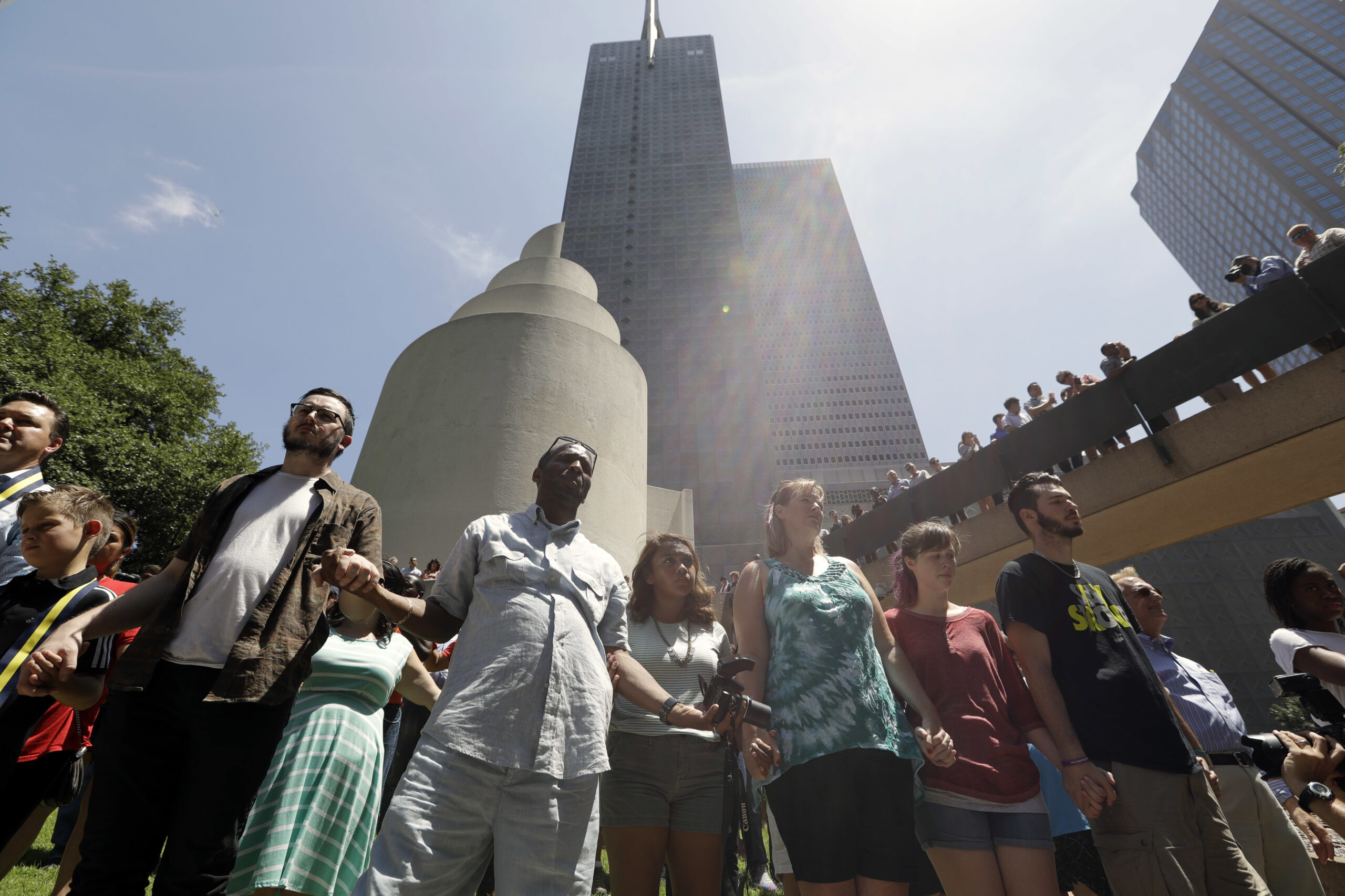 People join hands as they take part in a prayer vigil at Thanksgiving Square, Friday in Dallas. (AP)