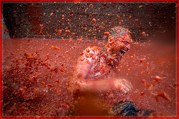 A reveller is pelted with tomato pulp during the annual "tomatina" festivities in the village of Bunol, near Valencia on August 31, 2016.  
Today at the annual Tomatina fiesta 160 tonnes of ripe tomatoes were offloaded from trucks into a crowd of 22,000 half-naked revellers who packed the streets of Bunol for an hour-long battle.



 / AFP / BIEL ALINO        (Photo credit should read BIEL ALINO/AFP/Getty Images) (Afp/getty Images)