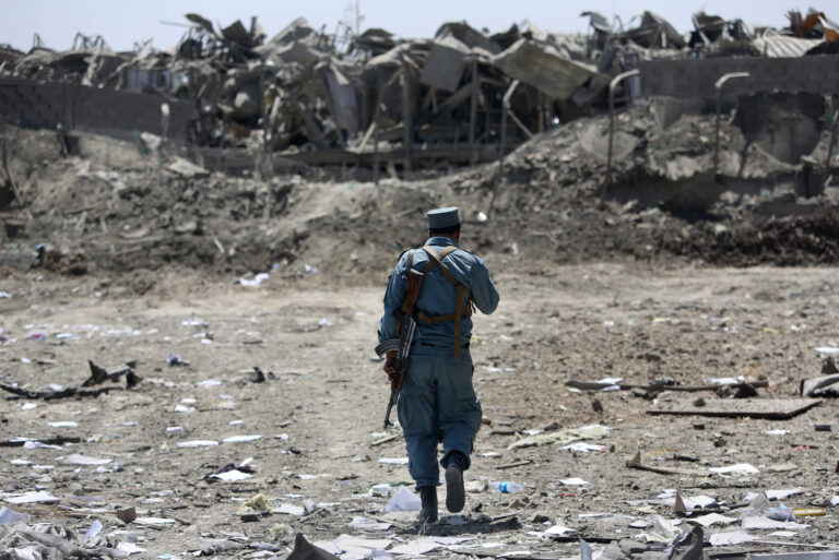 FILE - In this Monday, Aug. 1, 2016 file photo, an Afghan Security policeman inspects the site of a suicide truck bombing, in Kabul, Afghanistan. (AP)