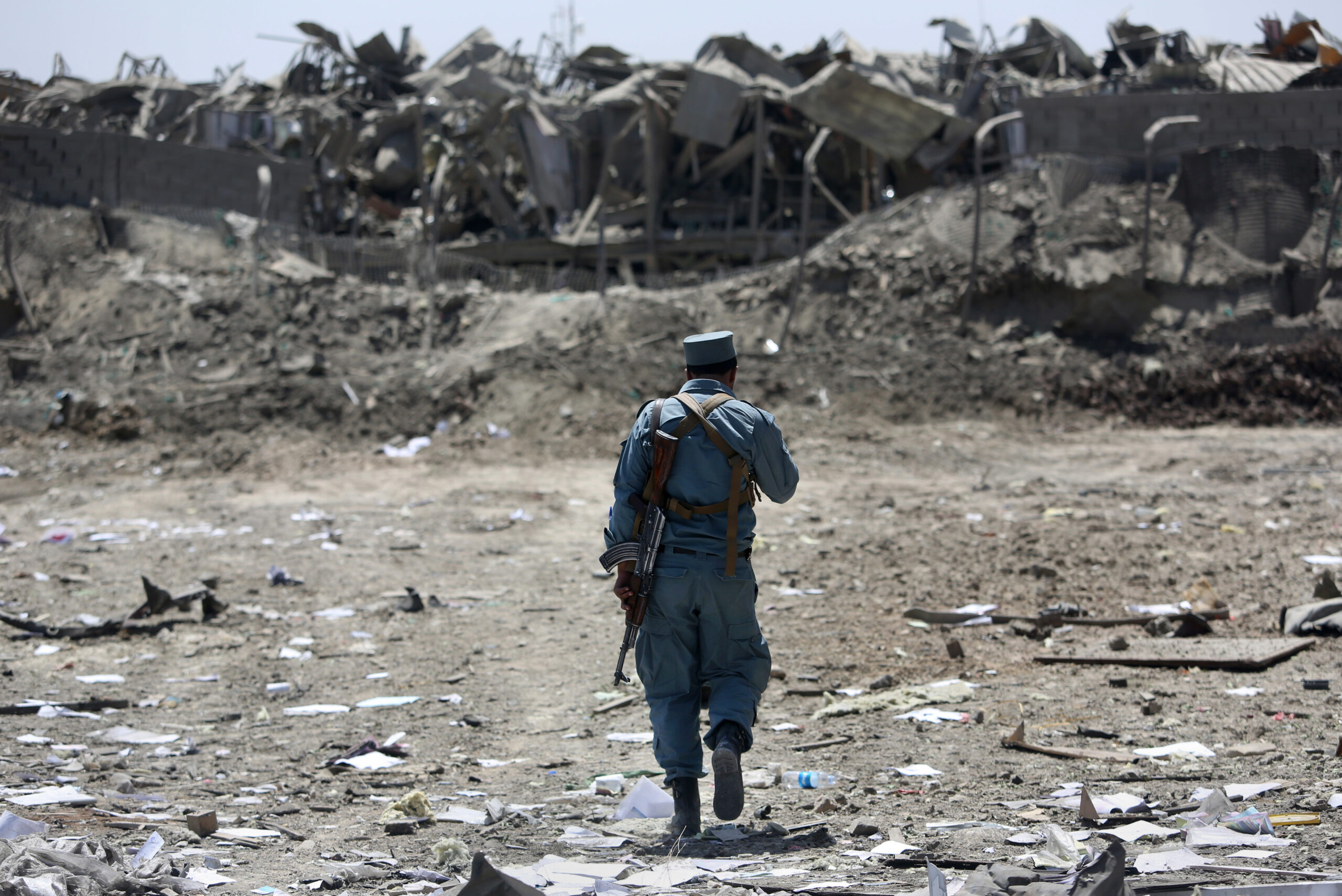 FILE - In this Monday, Aug. 1, 2016 file photo, an Afghan Security policeman inspects the site of a suicide truck bombing, in Kabul, Afghanistan. (AP)