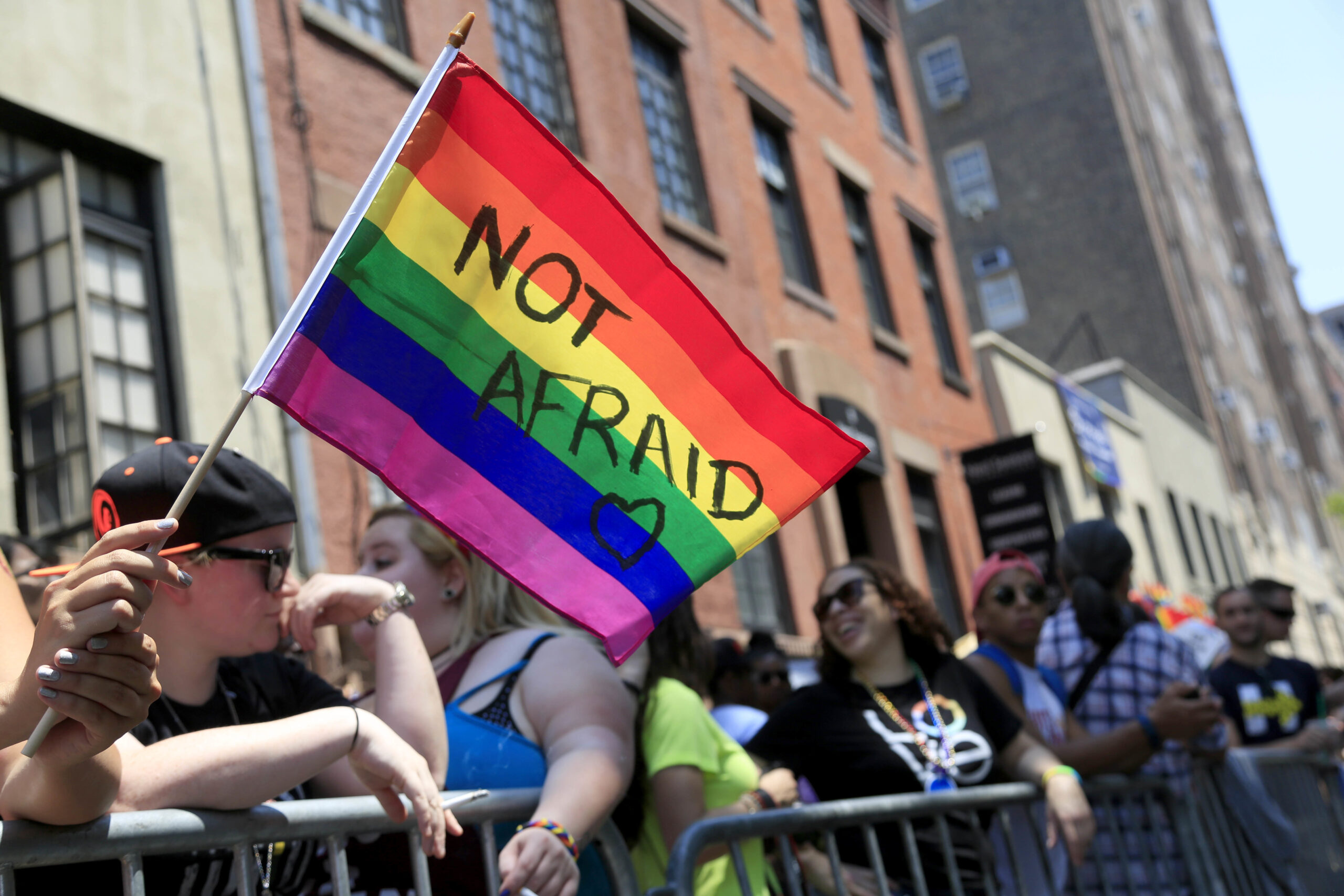 FILE - In this June 26, 2016, file photo, a woman holds a rainbow flag during the NYC Pride Parade in New York. Young Americans overwhelmingly say they support LGBT rights when it comes to employment, health care and adoption. That’s according to a new GenForward survey, which finds 92 percent of young adults support HIV and AIDs prevention, 90 percent support equal employment, and 80 percent support LGBT adoption. Across ethnic groups, large majorities of Americans aged 18 to 30 favor training police on transgender issues, government support for LGBT youth organizations and insurance coverage for transgender health issues. (AP Photo/Seth Wenig, File) (AP)