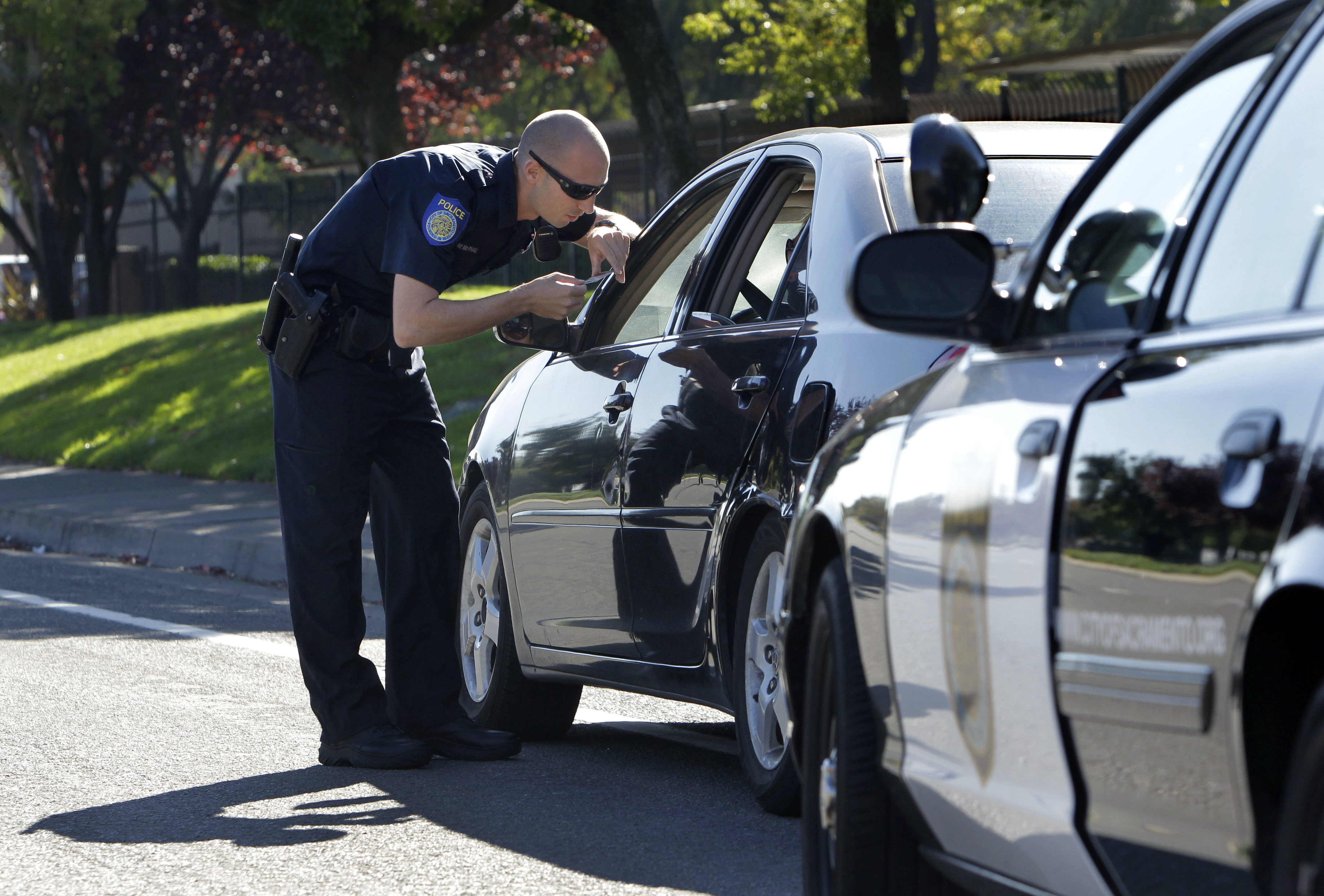 FILE - In this Nov. 12, 2012 file photo, A Sacramento Police Officer makes a traffic stop in Sacramento Calif. Young African-American adults say they are arrested and that they or someone they know has been harassed by police in far greater numbers than any other young Americans, despite the fact that a newly released poll shows they encounter police at just about the same rate as white, Hispanic and Asian adults their same age.  (AP Photo/Rich Pedroncelli, File) (AP)