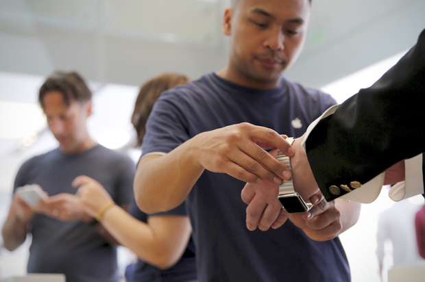 An Apple employee assists a customer with a new Apple Watch in San Francisco, June 17, 2015. (Reuters/Robert Galbraith)
