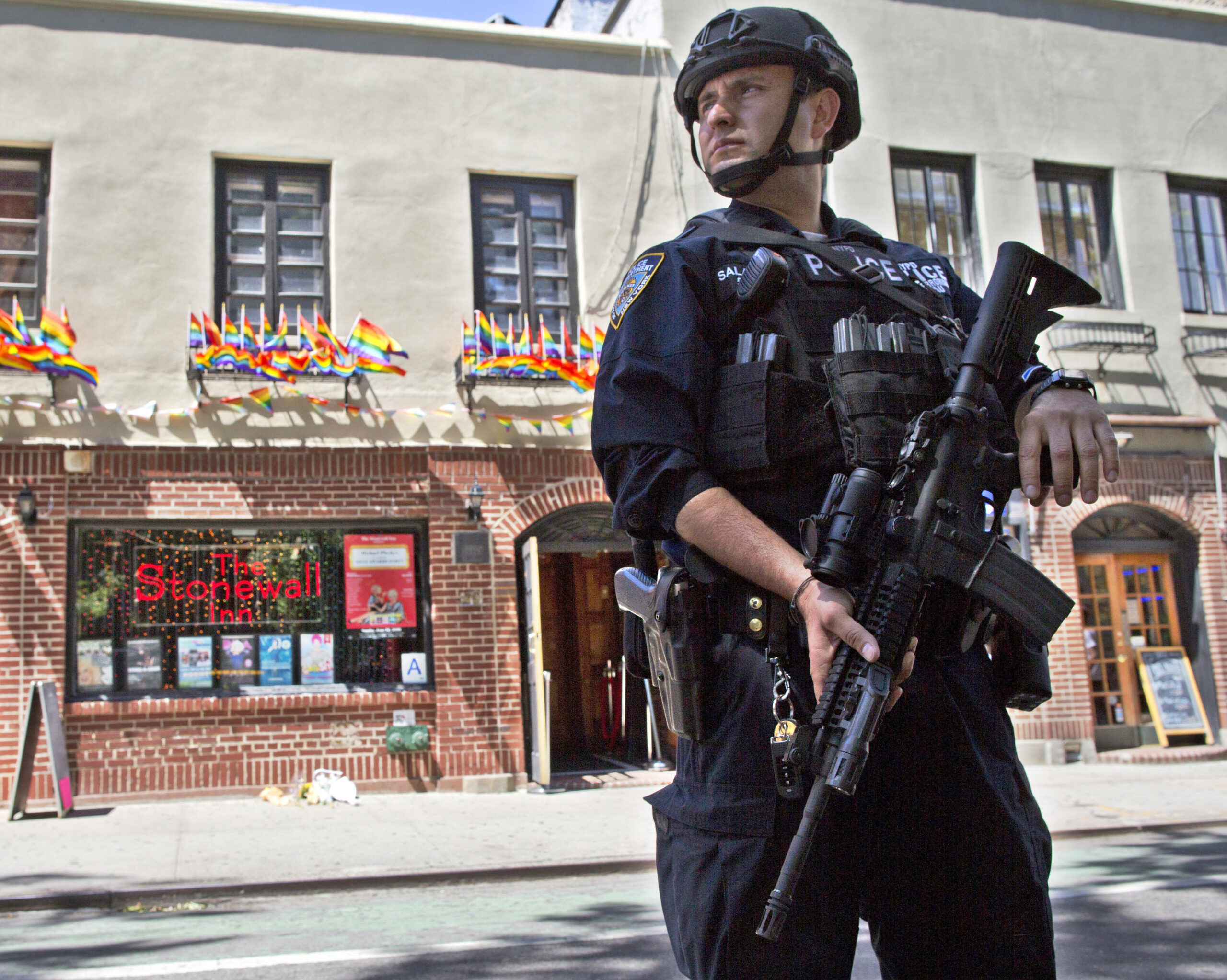 FILE - In this June 12, 2016 file photo, an armed police officer stands guard outside the Stonewall Inn, in New York after a Florida gunman's attack at a gay nightclub spread fear of more attacks. The officer is heavily armed and equipped, in a manner typical of the NYPD's counterterrorism unit and Emergency Service Unit - the NYPD's equivalent of SWAT officers. But the NYPD plans to distribute 20,000 helmets and 6,000 vests before the end of the year to uniformed patrol officers to protect them better during combat with rampaging shooters (AP Photo/Mary Altaffer, File) (AP)
