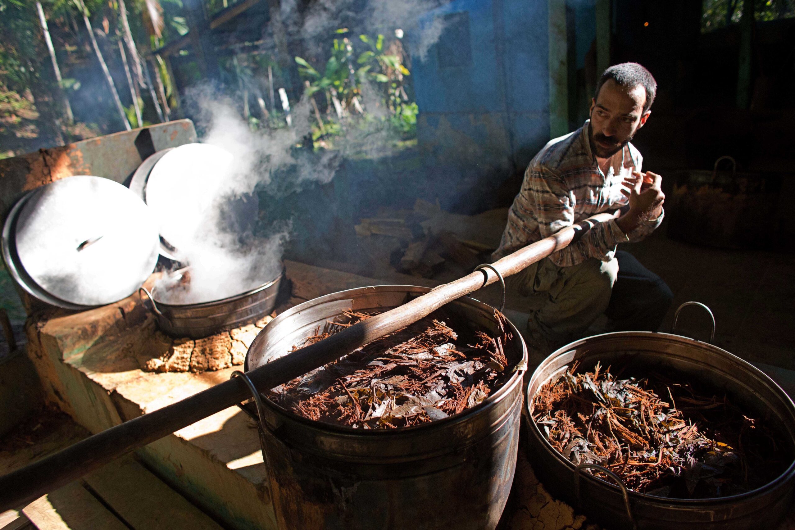 In this June 22, 2016 poto, a man moves a cauldron used for brewing a psychedelic tea locals know as the Holy Daime in Ceu do Mapia, Amazonas state, Brazil. Ayahuasca brew is sacred to Ceu do Mapia villagers, who use it in rituals that blend together Indian beliefs with Roman Catholicism. (AP Photo/Eraldo Peres) (AP)