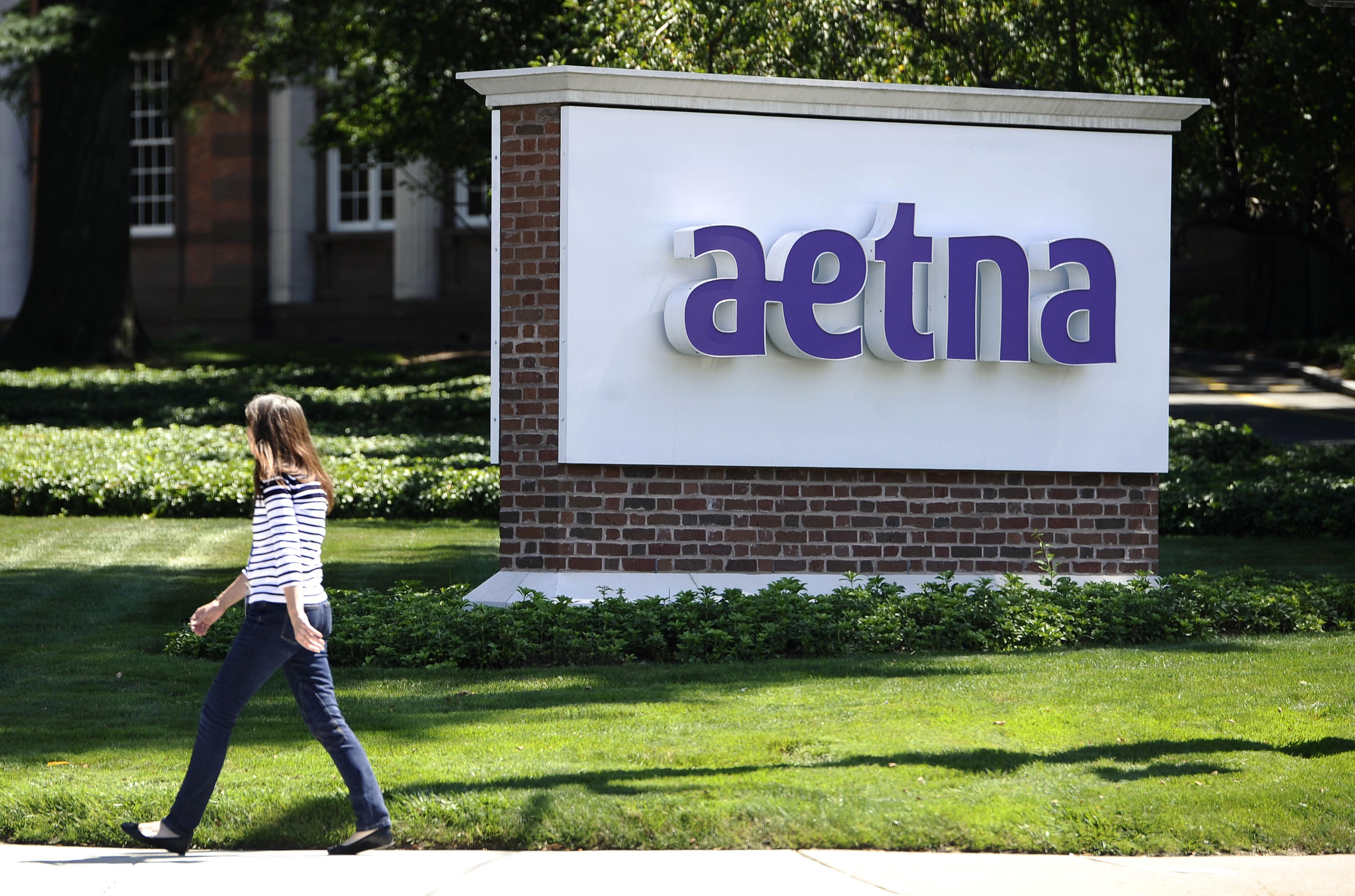FILE - In this Tuesday, Aug. 19, 2014, file photo, a pedestrian walks past a sign for health insurer Aetna Inc., at the company headquarters in Hartford, Conn. Aetna Inc. reports financial results Tuesday, Aug. 2, 2016. (AP Photo/Jessica Hill, File) (AP)