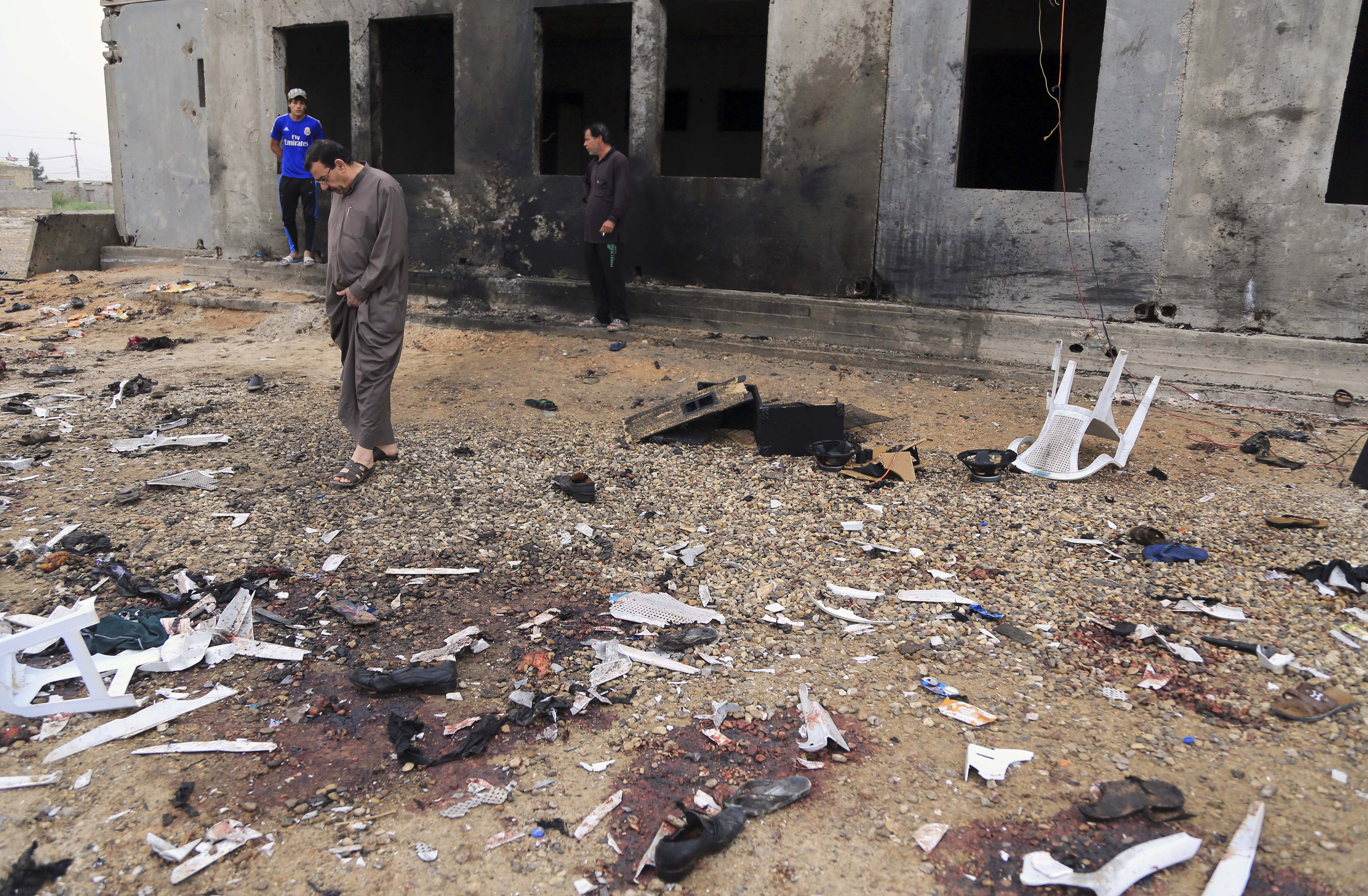 FILE - In this March 26, 2016, file photo, people inspect the aftermath of a suicide bombing that killed 29 and wounded 60 at a soccer field in Iskandariya, 25 miles (about 40 kilometers) south of Baghdad, Iraq. The Islamic State group claimed responsibility and released a photo of the attacker where he appears to be no more than 16 years old. The suicide attacker who detonated his explosives amid an outdoor Kurdish wedding party, Saturday, Aug. 20, 2016, in southeastern Turkey, killing at least 51 people, was an Islamic State group child as young as 12 years old. (AP Photo/Karim Kadim, File) (AP)