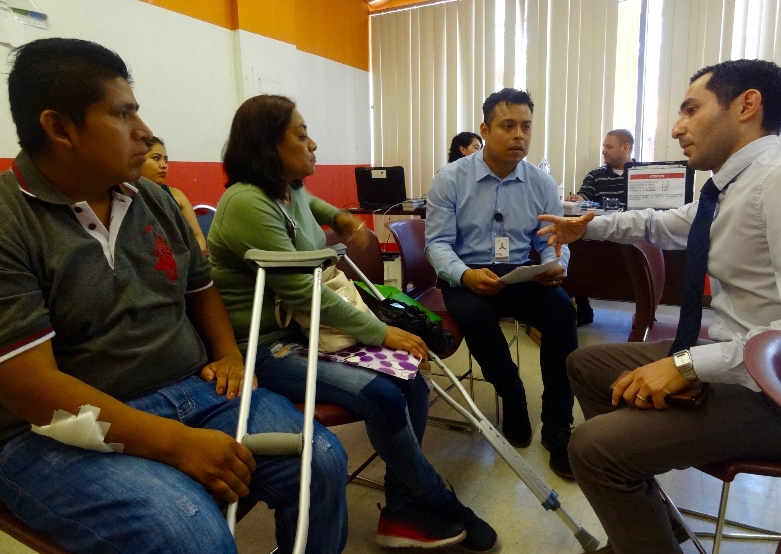 Fidencio Luna (left) sits with his wife and the executive director of the immigrant rights organization El Centro in Staten Island as he fills out paperwork to receive his first Mexican passport. Photo courtesy of Amy Lieberman. (Amy Lieberman)