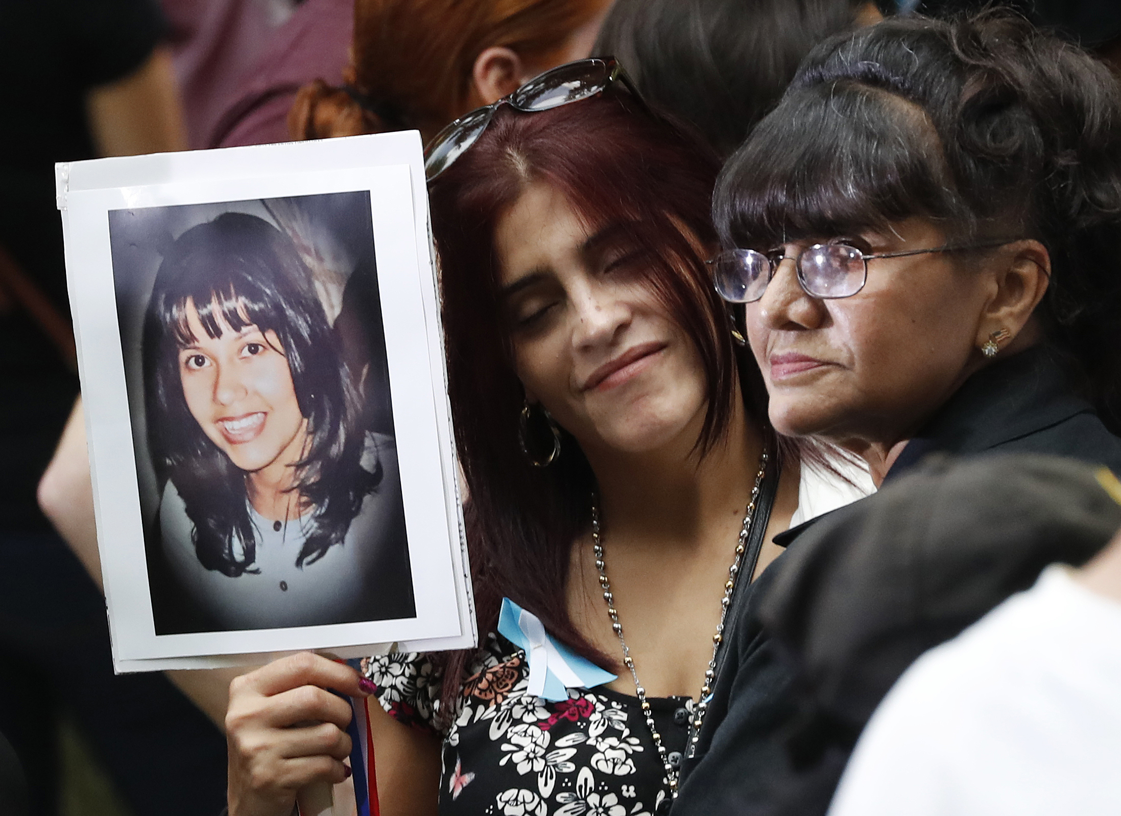 Mourners hold a photo of their loved one during the 15th anniversary of the attacks of the World Trade Center at the National September 11 Memorial, Sunday, Sept. 11, 2016, in New York. ( (AP)
