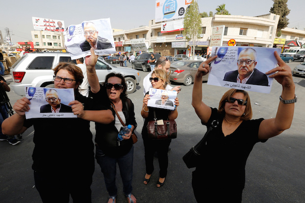 Relatives and friends of the Jordanian writer and activist Nahed Hattar hold pictures of him during a protest in the town of Al-Fuheis, near Amman, Jordan, on September 25, 2016 (Reuters/Muhammad Hamed)