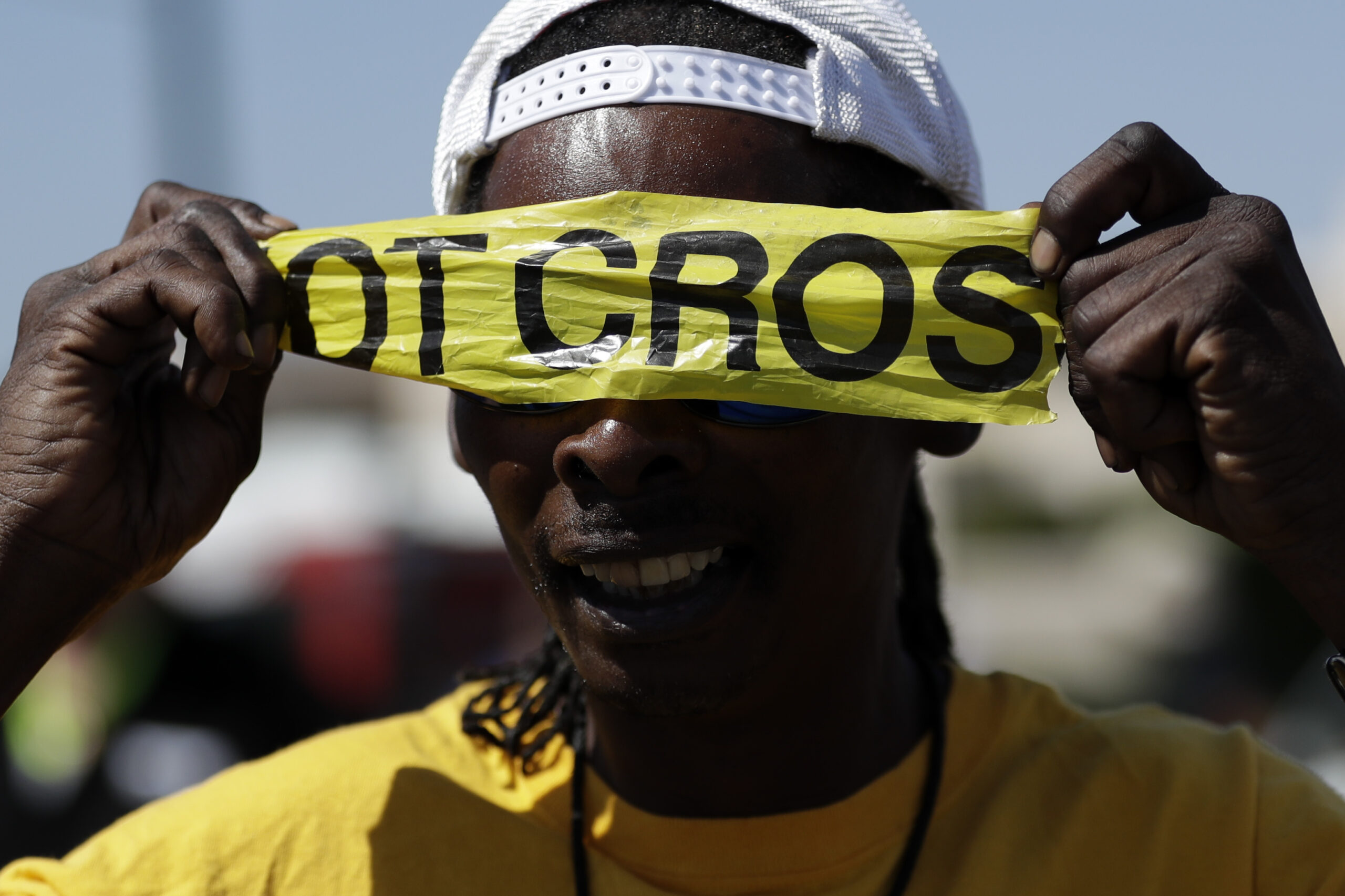A man covers his eyes with police tape during a protest, Wednesday, Sept. 28, 2016, in El Cajon, Calif. Dozens of demonstrators on Wednesday protested the killing of a black man shot by an officer after authorities said the man pulled an object from a pocket, pointed it and assumed a "shooting stance." (AP Photo/Gregory Bull) (AP)