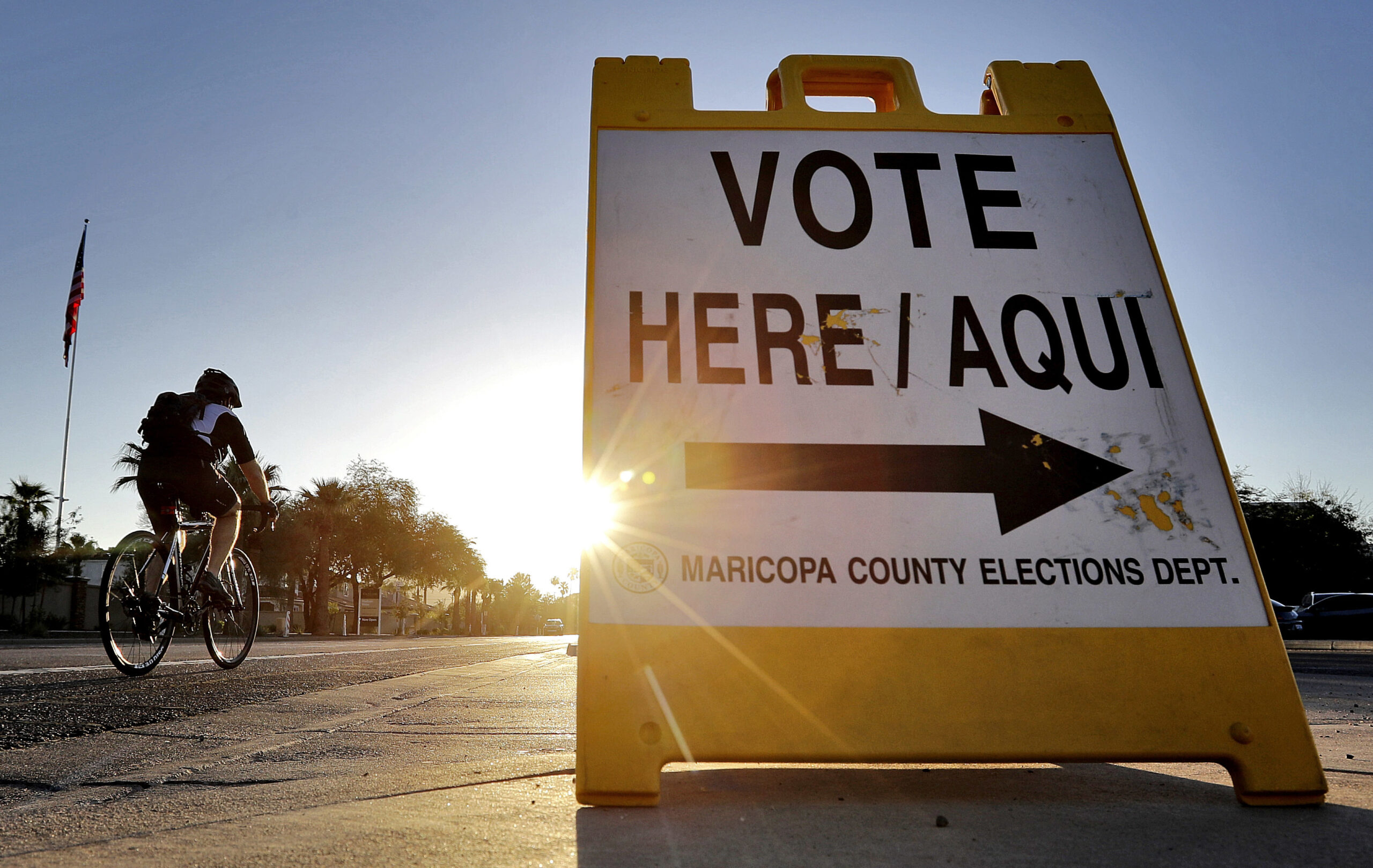 FILE - In this Aug. 30, 2016 file photo, a cyclist rides past a sign directing voters to a primary election voting station early, in Phoenix. Early voting kicks off next week in North Carolina, the first in a two-month run of voting through key swing states where non-whites and young adults could give one of the presidential campaigns a decisive advantage before Election Day.   (AP Photo/Matt York, File) (AP Photo/Matt York, File)