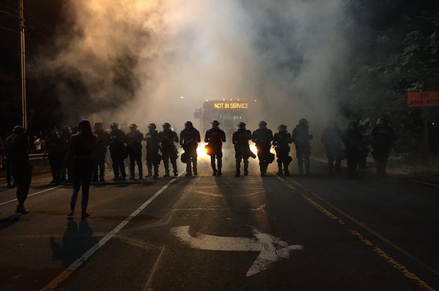 Police in riot gear use teargas to disperse protesters after police killed a disabled black man in Charlotte, North Carolina on Tuesday, September 20, 2016 (Adam Rhew/Charlotte magazine)