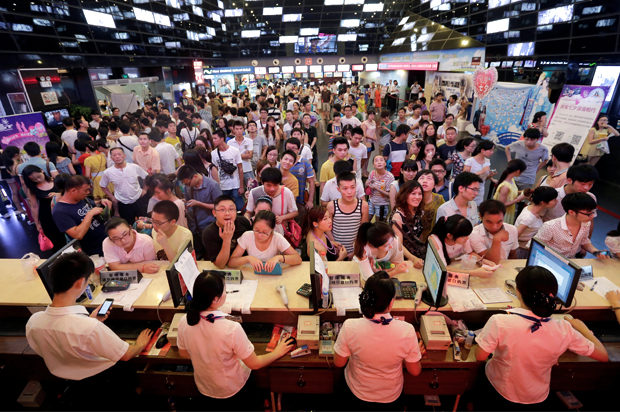 People wait for tickets at a movie theatre in Wuhan, Hubei province, China, August 13, 2013. (Reuters/Darley Shen)