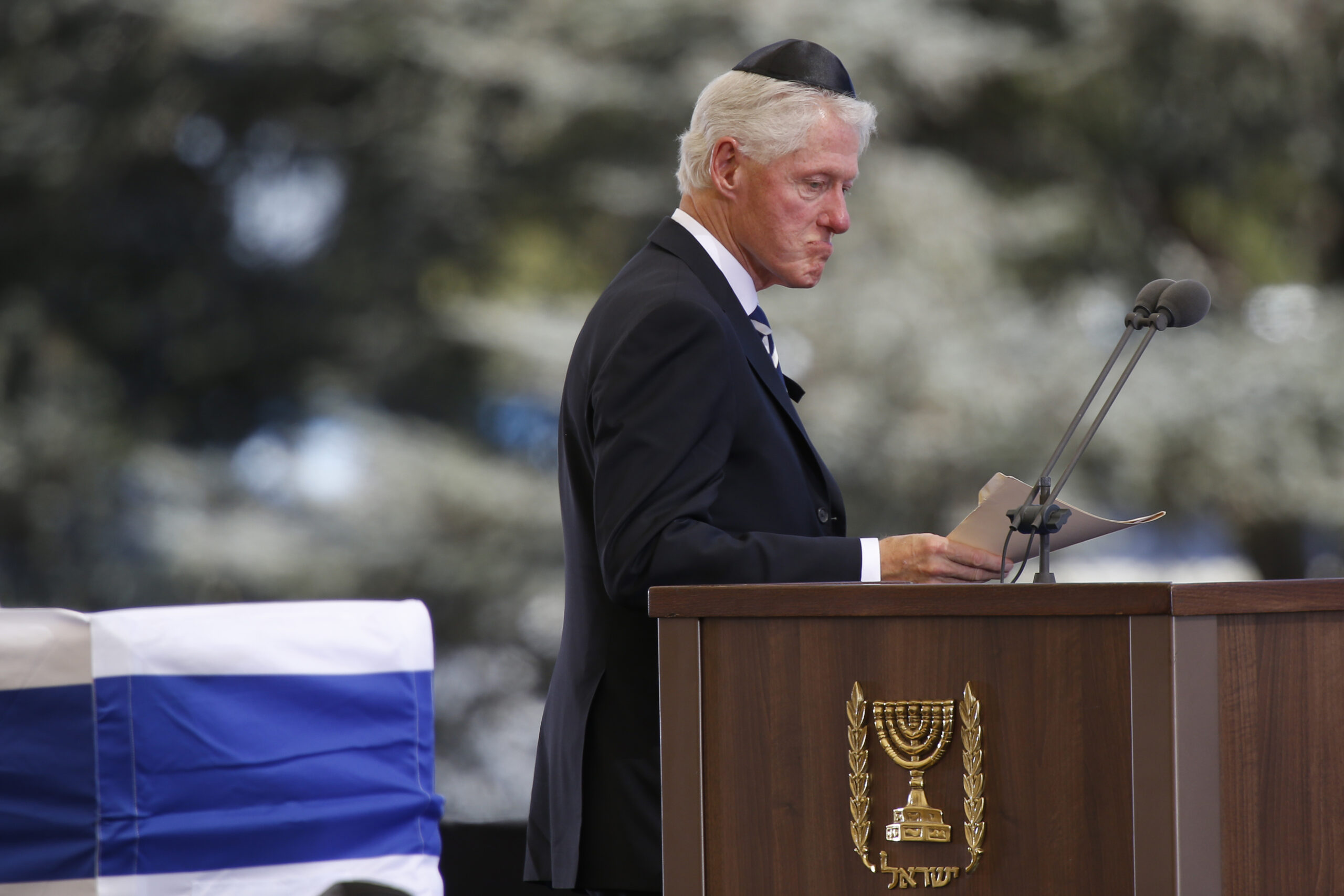 Former US President Bill Clinton passes the flag-draped coffin of former Israeli President Shimon Peres during his funeral at the Mount Herzel national cemetery in Jerusalem, Friday, Sept. 30, 2016. (AP Photo/Ariel Schalit) (AP)