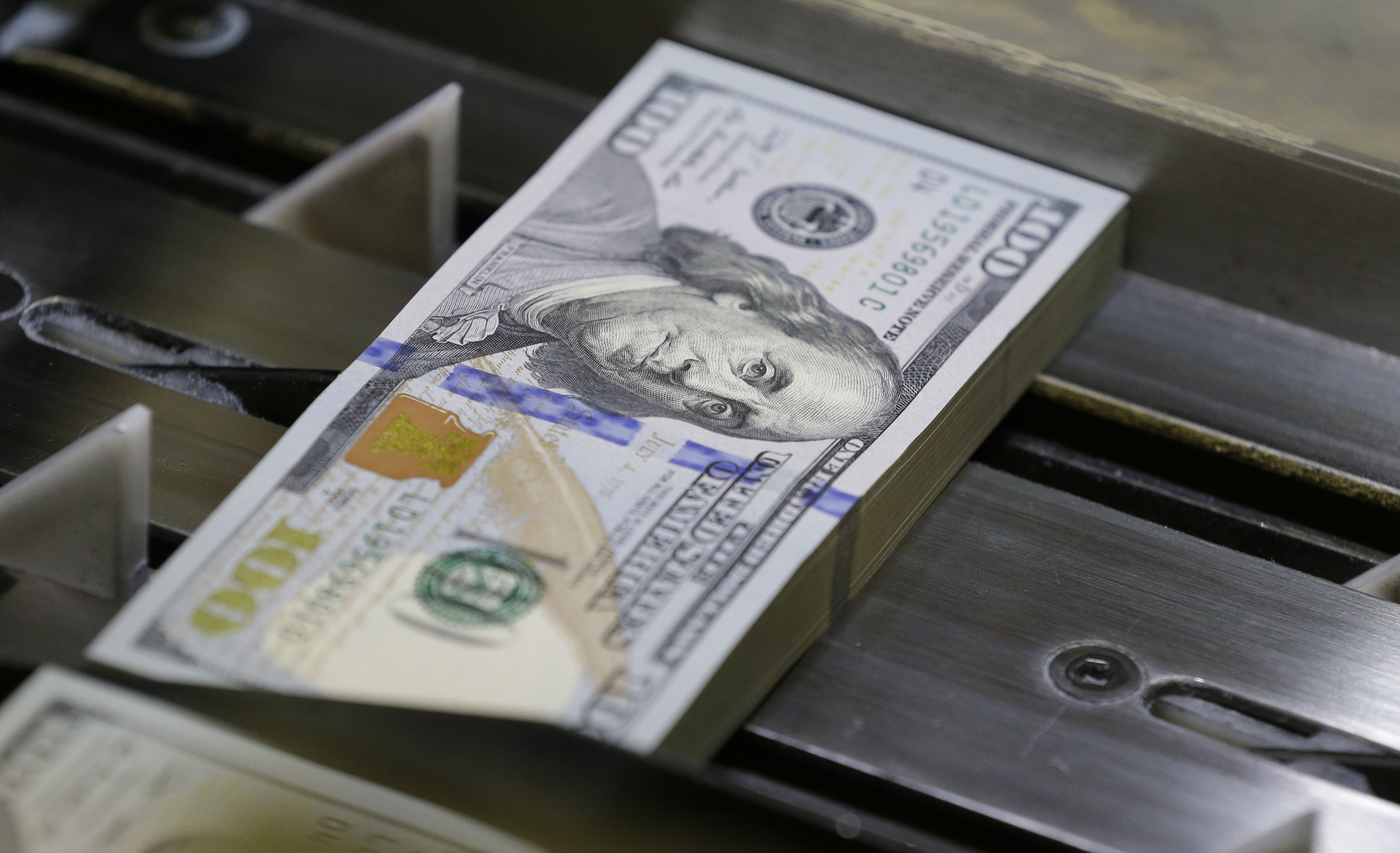 FILE - In this Tuesday, Sept. 24, 2013, file photo, a just-cut stack of $100 bills rolls down the line at the Bureau of Engraving and Printing Western Currency Facility in Fort Worth, Texas. Finding money you didn’t know you had is like discovering lost treasure. Nearly $42 billion in unclaimed property is sitting in state coffers, waiting to be matched with its owners or their heirs. () (AP Photo/LM Otero, File)