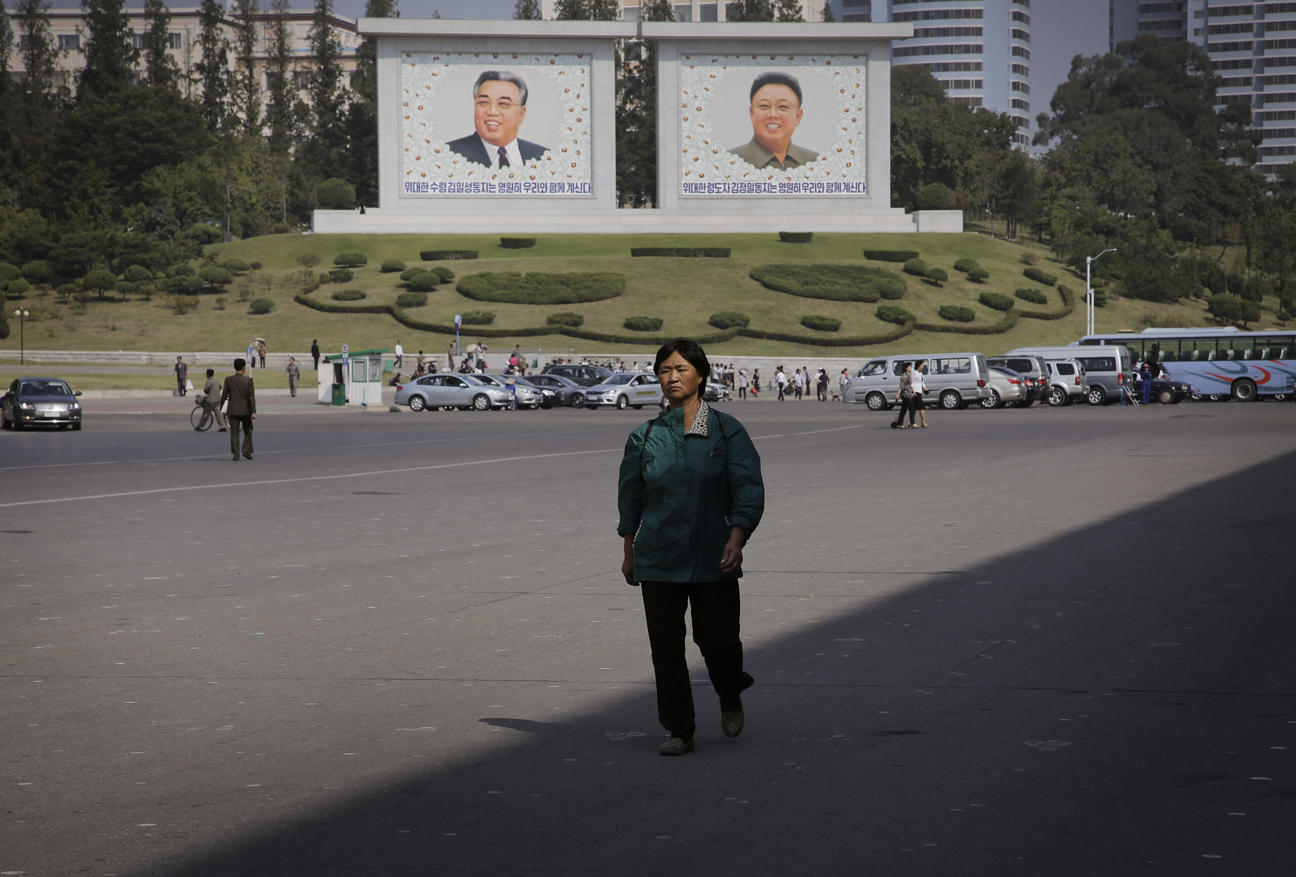 In this Friday, Sept. 23, 2016, photo, a North Korean woman walks down the street where murals of the late North Korean leaders Kim Il Sung, left, and Kim Jong Il decorate the streets in downtown Pyongyang, North Korea. (AP)