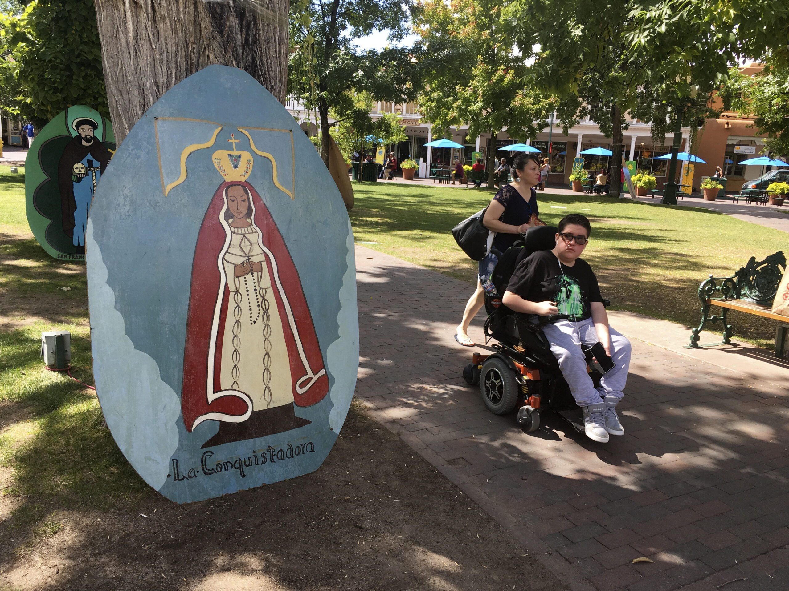 This Sept. 1, 2016 photo shows visitors of Santa Fe Plaza pass by an image of La Conquistadora, oldest statue of the Blessed Virgin Mary in the United States, as organizers prepare for the annual Santa Fe Fiesta.  For centuries, northern New Mexico Hispanic residents have held an elaborate festival in Santa Fe in honor of Spanish conquistador Don Diego De Vargas’ who reclaimed the city following an American Indian revolt.  But after 301 years, an emboldened group of Native American activists say it’s time to change a celebration centered around the conquest of New Mexico’s Pueblo tribes.  (AP Photo/Russell Contreras) (AP)