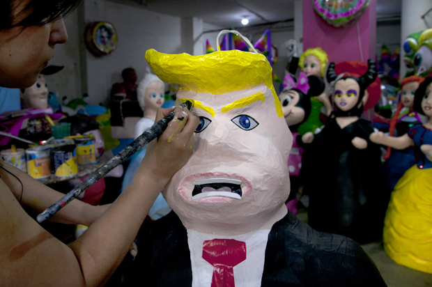 Alicia Lopez Fernandez paints a pinata depicting Donald Trump at her family's store in Mexico City, July 10, 2015. (AP/Marco Ugarte)