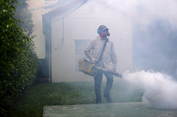 A mosquito control inspector sprays pesticide to kill mosquitos in Miami Beach, Florida, August 24, 2016. (Getty/Joe Raedle)