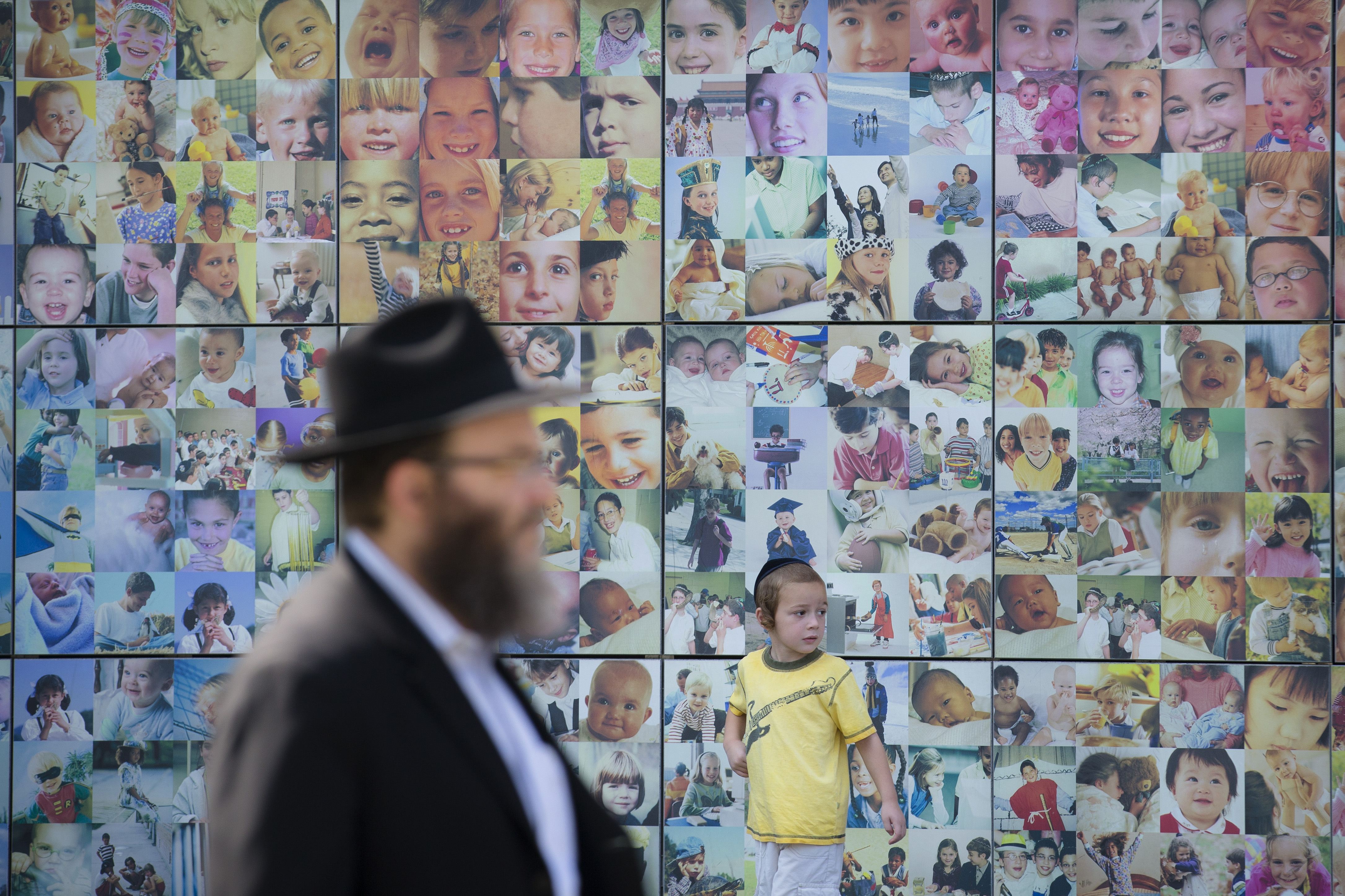 An Orthodox Jewish child walks alongside a collage wall at the Jewish Children's Museum, Monday, Aug. 11, 2014, in the Brooklyn borough of New York. The museum is the largest Jewish-themed children's museum in the United States. (AP Photo/John Minchillo) (AP)