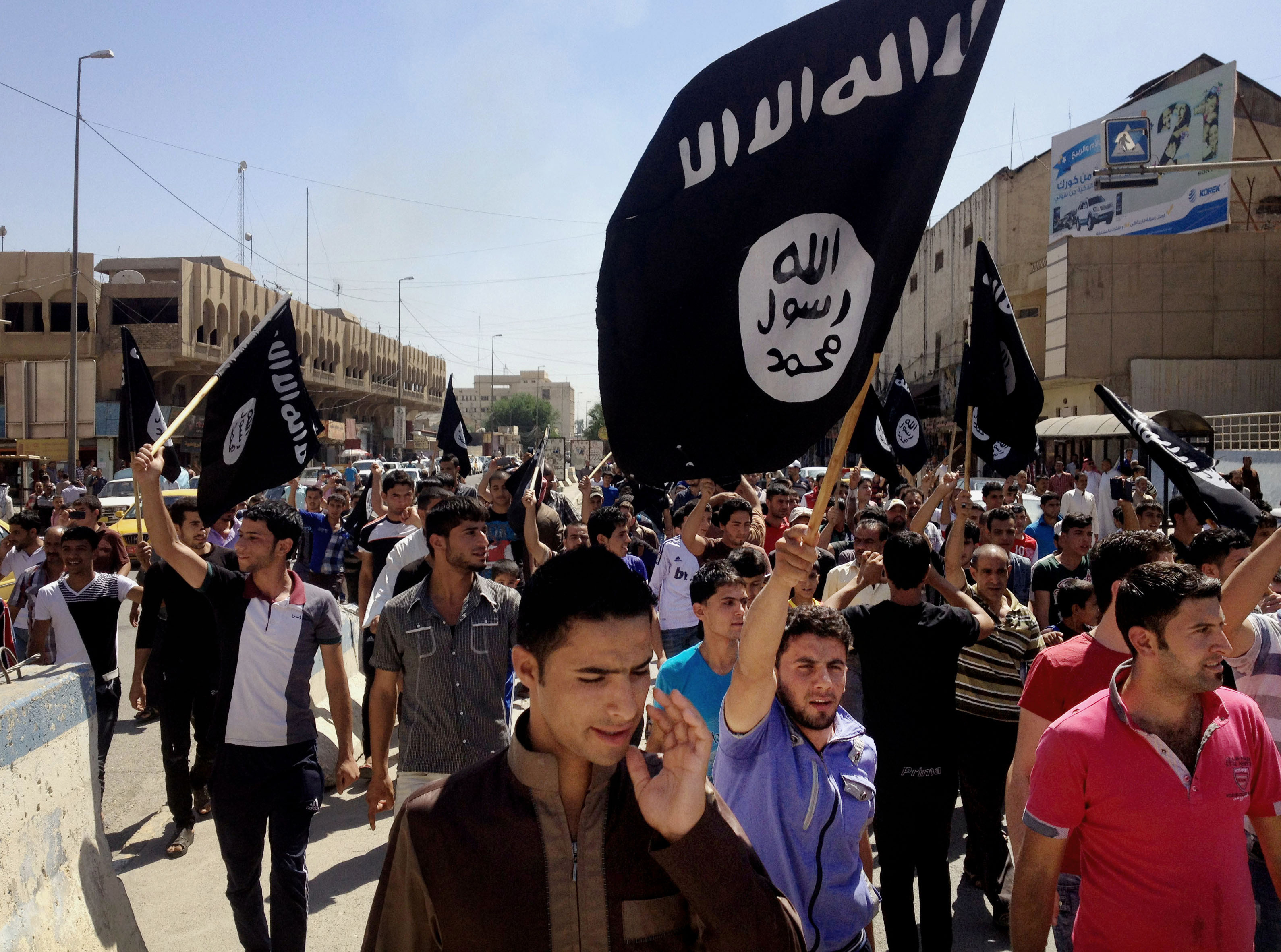 FILE - In this June 16, 2014. file photo, demonstrators chant pro-Islamic State group slogans as they carry the group's flags in front of the provincial government headquarters in Mosul, Iraq. (AP)
