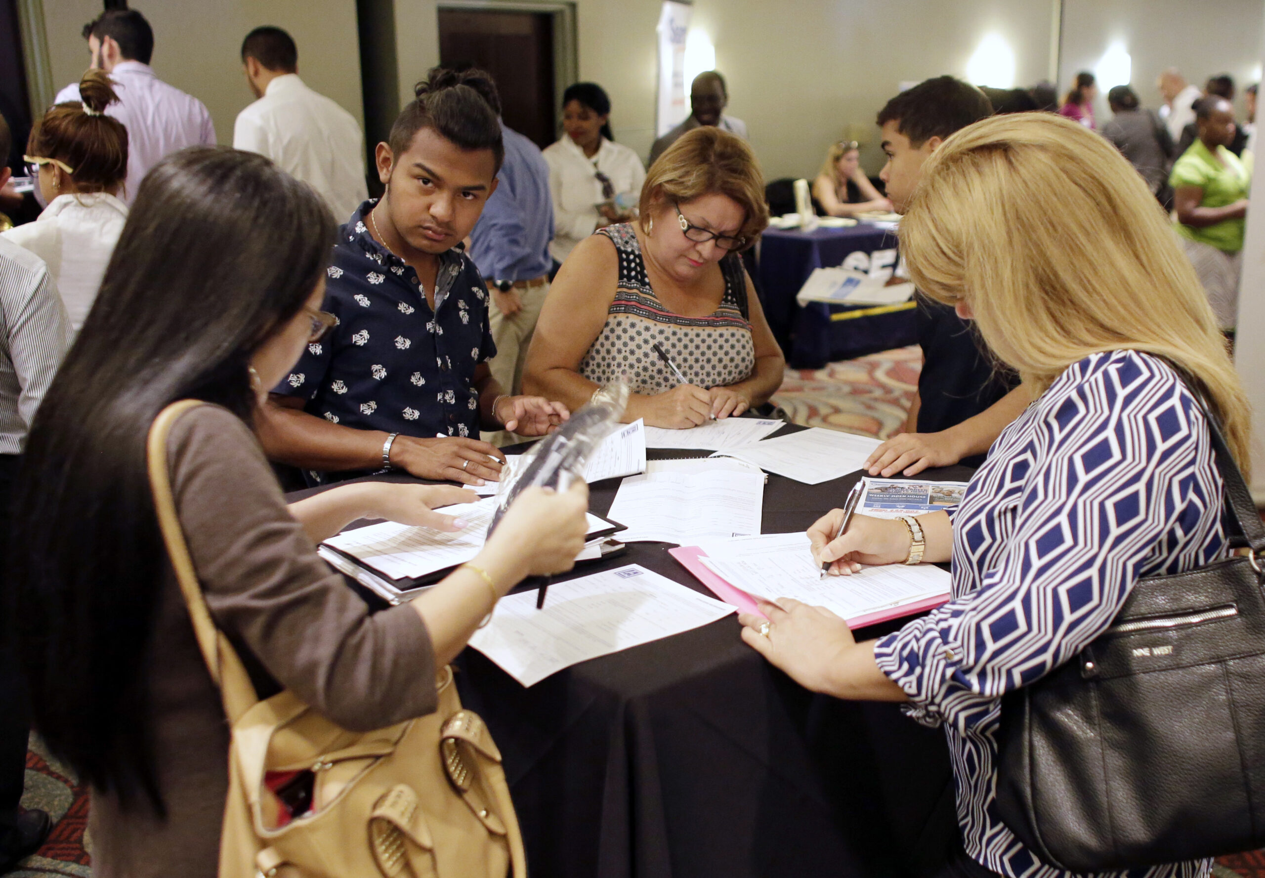 FILE - In this July 19, 2016, file photo, people fill out job applications at a job fair in Miami Lakes, Fla. Tepid income growth and shrinking opportunities for blue-collar workers have kept many Americans anxious about jobs and the economy, seven years after the Great Recession ended. The unemployment rate has fallen to a relatively low 4.9 percent. But many Americans are struggling to keep up with an economy that has been fundamentally transformed since the recession, and is very different from the one their parents experienced. (AP Photo/Lynne Sladky, File) (AP Photo/Lynne Sladky)