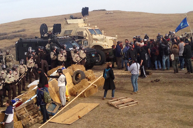 A line of police move towards a roadblock and encampment of Native American and environmental protesters near an oil pipeline construction site, near the town of Cannon Ball, North Dakota, U.S. October 27, 2016 (Reuters/Rob Wilson)