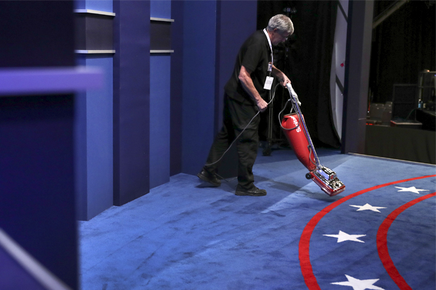 A stage hand vacuums the carpet before the third and final debate (AP/Joe Raedle)