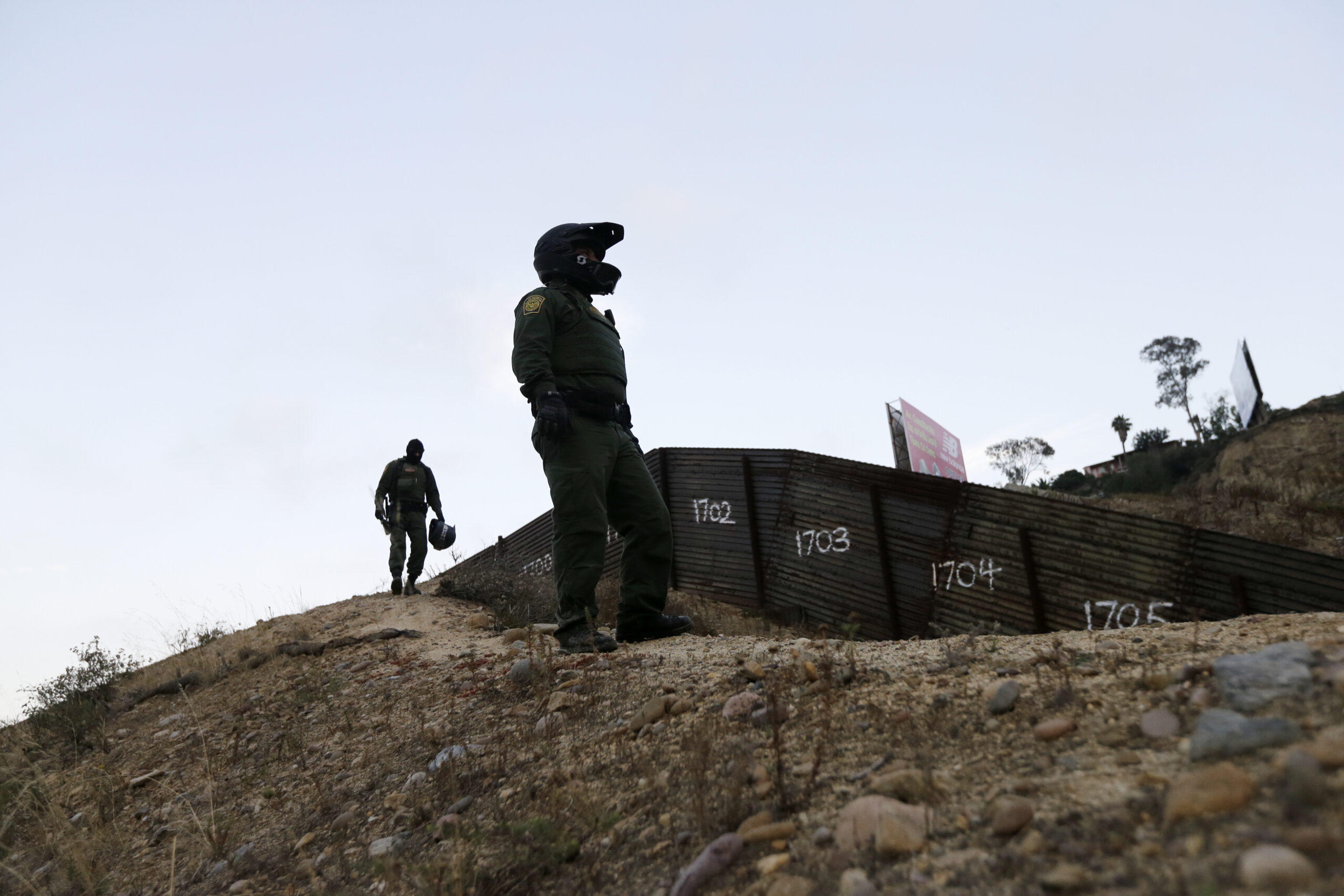 FILE - In this Wednesday, June 22, 2016, file photo, Border Patrol agents look over the primary fence separating Tijuana, Mexico, right, and San Diego in San Diego. (AP)
