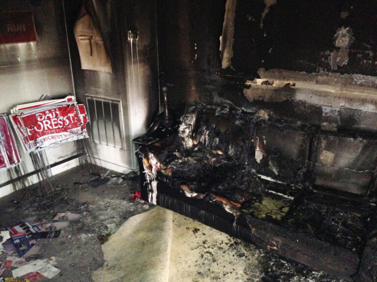 A burned couch is shown next to warped campaign signs at the Orange County Republican Headquarters in Hillsborough, NC on Sunday, Oct. 16 2016. (AP)