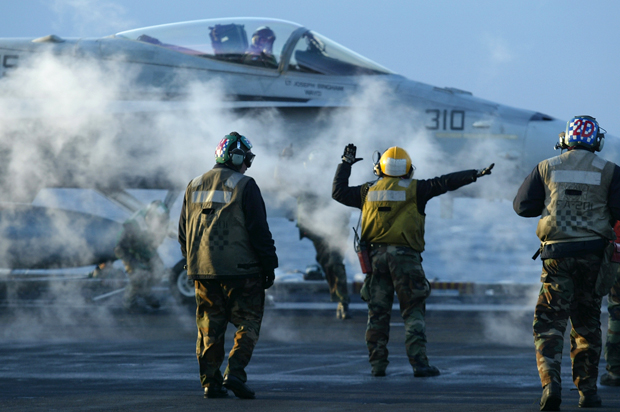 Flight deck crew prepare to launch an F/A 18 Hornet during early morning flight operations from the USS Theodore Roosevelt, Thursday March 20, 2003. (AP/Richard Vogel)