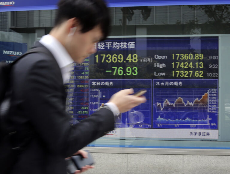 A man walks by an electronic stock board of a securities firm in Tokyo, Monday, Oct. 31, 2016. Asian stocks wobbled Monday as a revived FBI inquiry into U.S. presidential candidate Hillary Clinton's private email server sharpened uncertainty over the election, while investors also awaited key economic data this week. (AP Photo/Koji Sasahara) (AP)