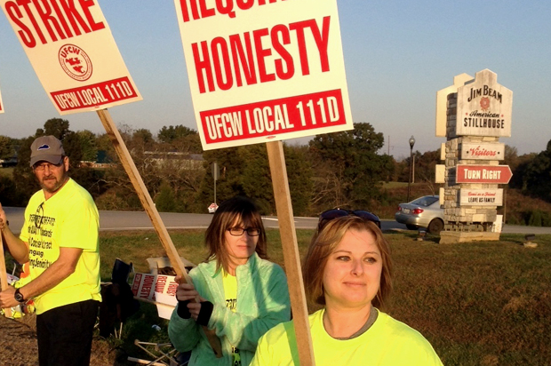 Workers hold picket signs outside the Jim Beam plant in Clermont, Ky. (AP/Bruce Schreiner)