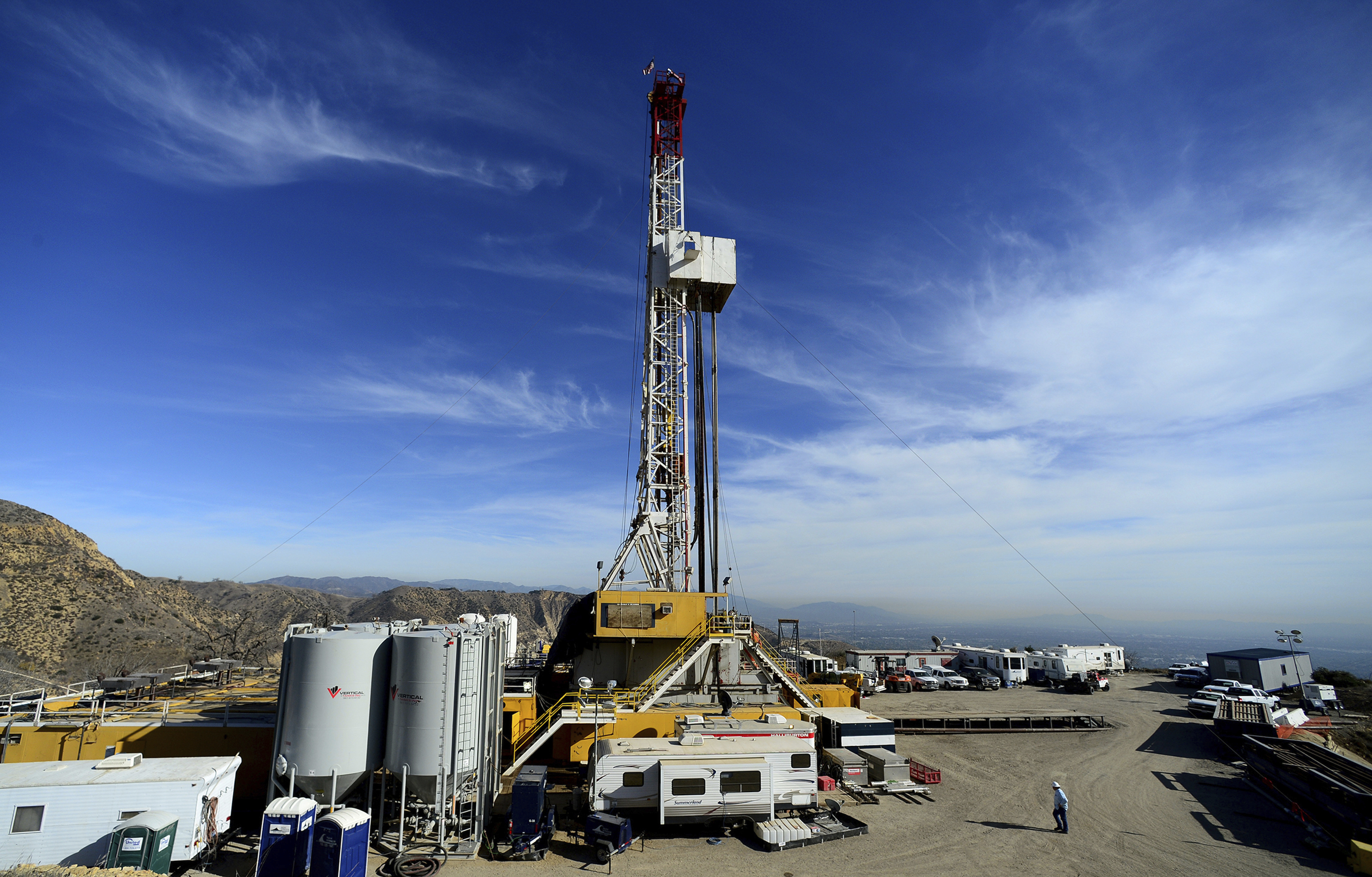 FILE - In this Dec. 9, 2015, file pool photo, crews work on a relief well at the Aliso Canyon facility above the Porter Ranch area of Los Angeles. A year after a leaking well near Los Angeles spewed natural gas for nearly four months and drove thousands of families from their homes, a White House task force is recommending dozens of changes to curtail leaks from the nation’s 400 underground natural gas storage wells. (Dean Musgrove/Los Angeles Daily News via AP, Pool, File)
