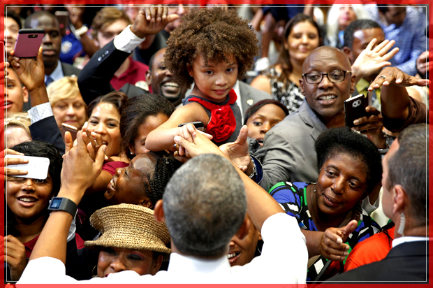 U.S. President Barack Obama shakes hands with a girl being held above the crowd during a Clinton-Kaine campaign rally at Florida Memorial University in Miami, October 20, 2016.   REUTERS/Kevin Lamarque  - RTX2PS3K (Reuters)